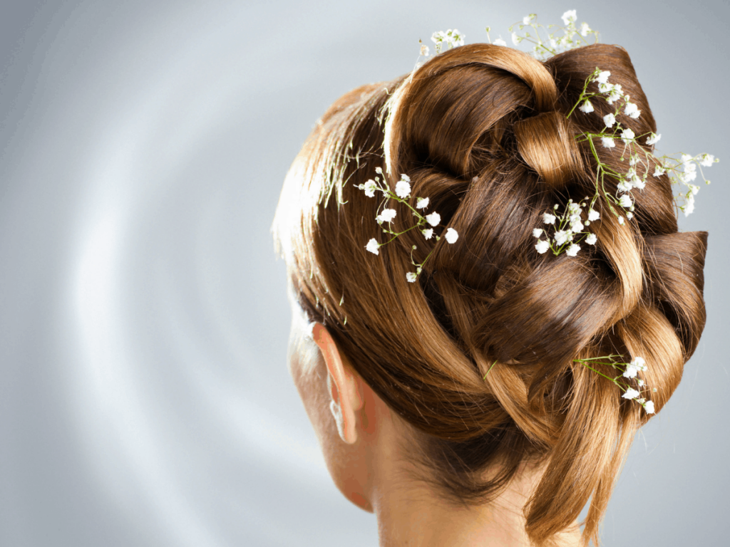 woman modeling a updo hairstyle with baby;s breath flowers in her hair.