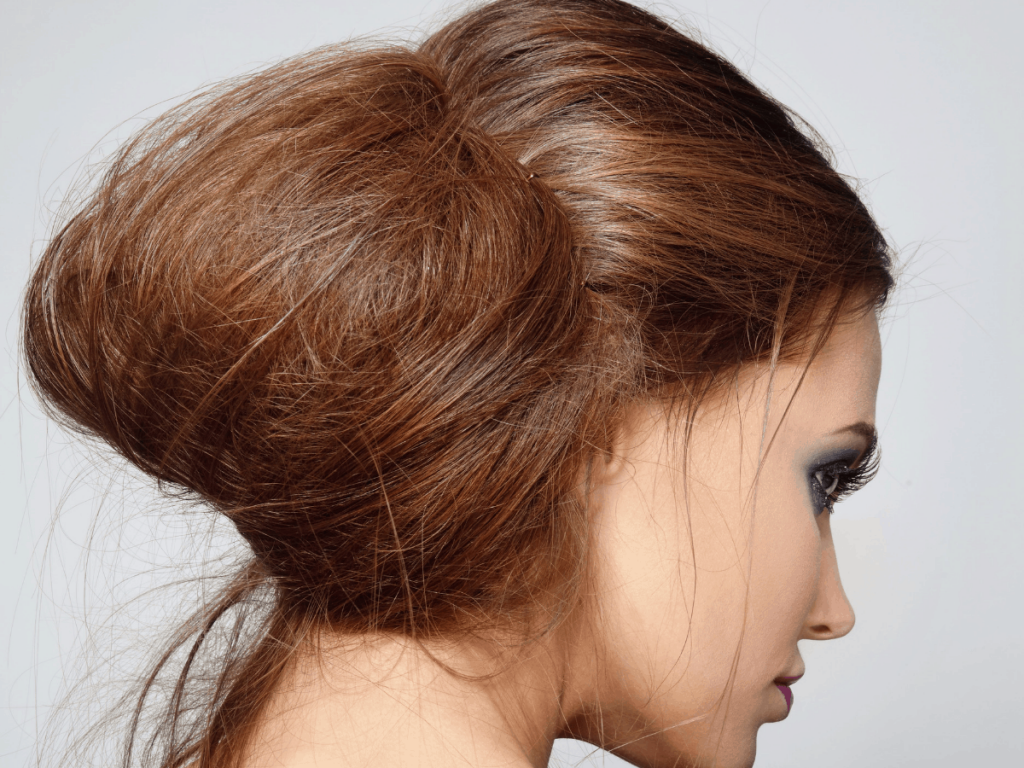 A woman modeling a messy bun hairstyle.