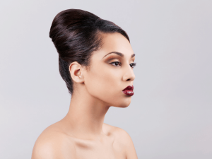 A woman preparing for modeling an updo hairstyle.