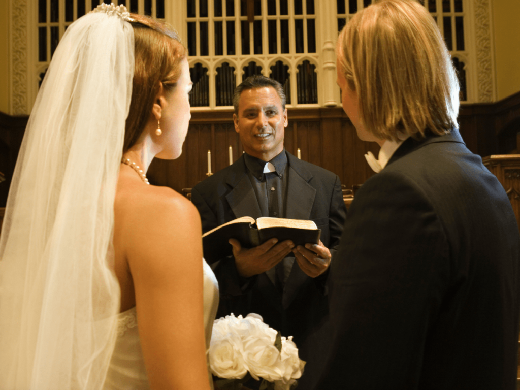 A couple standing before a minister during reading a christian ceremony script.