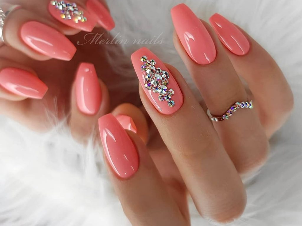 Salmon colored bridal nails with jewel accents