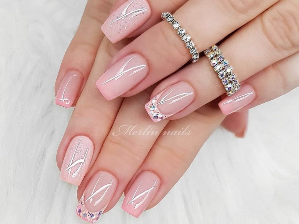 Light pink bridal nails with white artwork and ring accents.