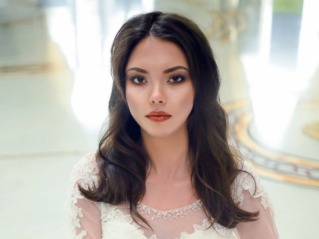 Woman wearing a wedding dress modeling a soft wave hairstyle.