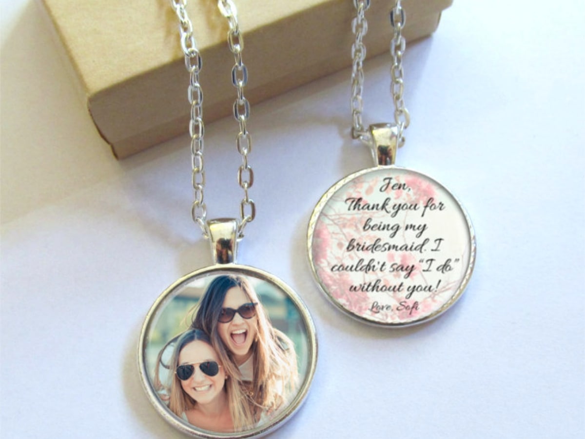 A bridesmaid necklace with a picture and message.