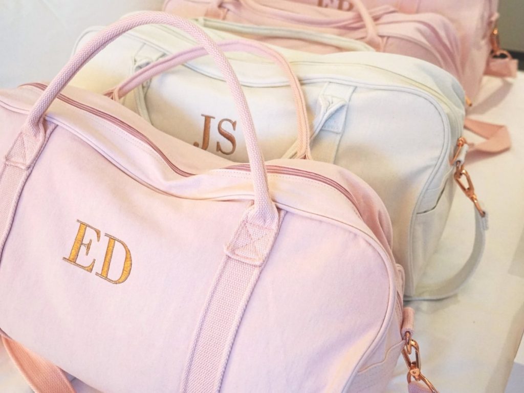 Duffle bags in assorted colors with your bridesmaid's initials on them.
