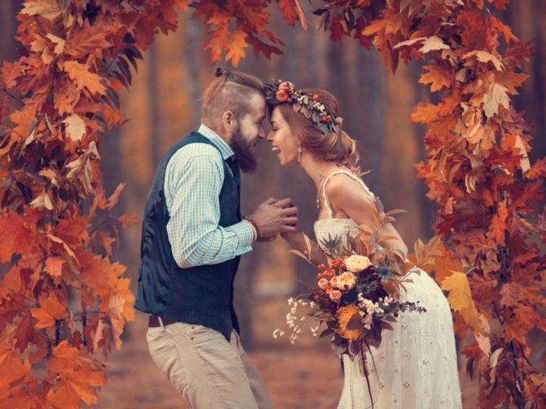 A couple getting married with beautiful wedding colors for fall surrounding them