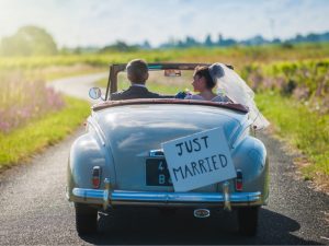 Couple just married driving away in a wedding vehicle
