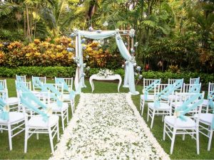 A small wedding altar in the garden with an aisle and chairs