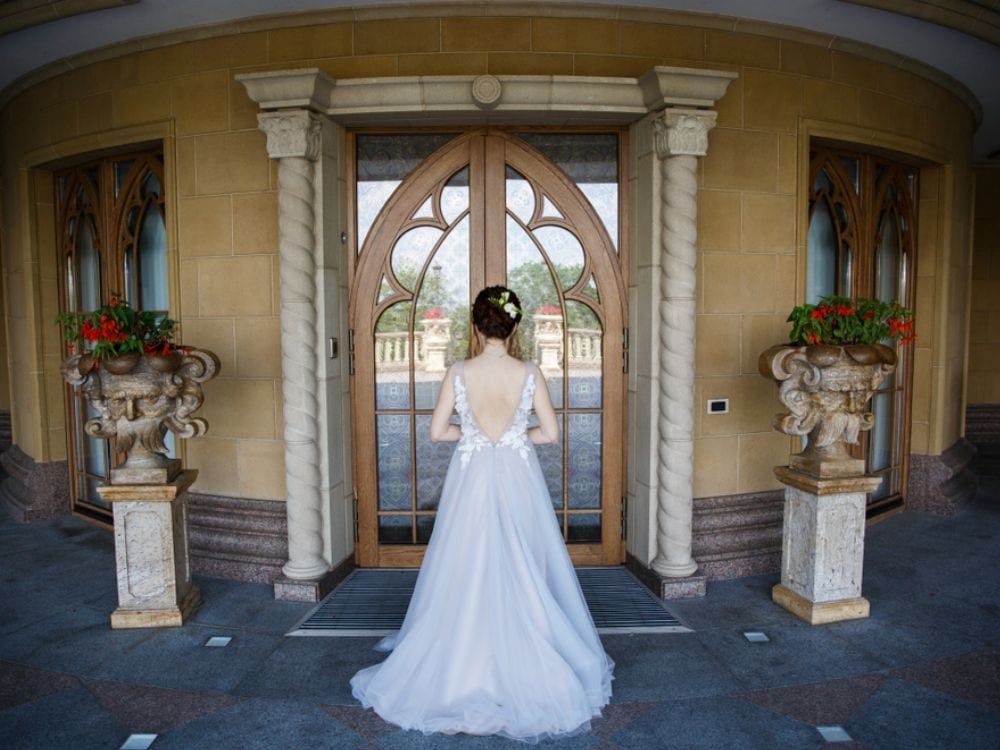 A bride standing in front of doors ready for the walk down the aisle