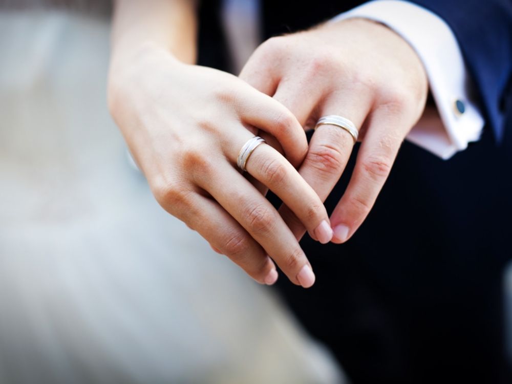 A married couples' hand wearing wedding rings